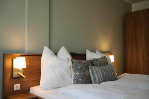 a bedroom with a bed with white sheets and pillows at Aparthaus Vergissmeinnicht in Söll