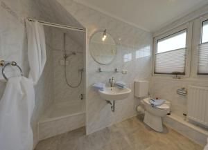 a bathroom with a sink and a shower and a toilet at Landhaus Dreesen in Timmendorfer Strand +23 photos