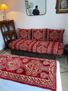 a red couch in a living room with a mirror at Dar Nour in Tangier