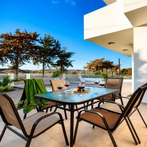 a dining table and chairs on a patio at Gennadi Villa Mare 300m from the Beach in Gennadi