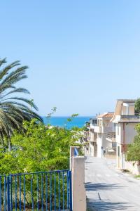 a street with buildings and the ocean in the background at Il Gabbiano rooms in Donnalucata