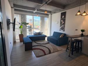 a living room with a blue couch and a table at Villa Celeste Guaduas El Mirador in Guaduas