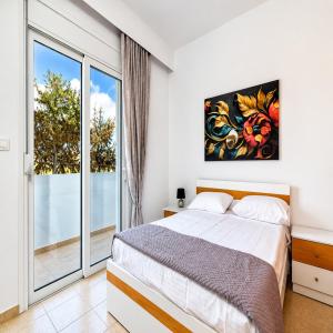 a bedroom with a bed and a large window at Gennadi Villa Mare 300m from the Beach in Gennadi