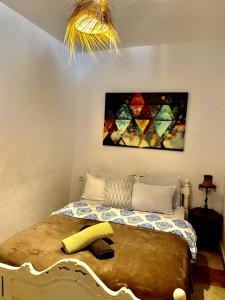 a bedroom with a bed with a painting on the wall at Nizar Surf Morocco in Taghazout