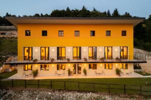 a large yellow house with tables and chairs at Chalet Bellavista in Spiazzi Di Caprino