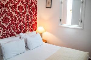 a bedroom with a white bed with a red wall at Dar Nour in Tangier