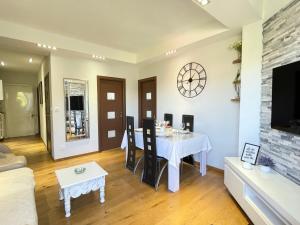 a living room with a table and a clock on the wall at Bella Stay in Cannes