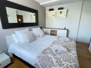 a bedroom with a white bed with a mirror on the wall at Bella Stay in Cannes