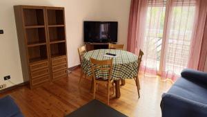 a dining room table with chairs and a tv at Casa Cretier in Aosta