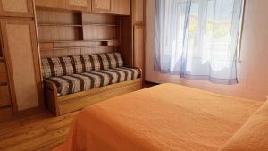 a bedroom with a bed and a window and a couch at Casa Cretier in Aosta