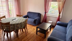 a living room with a table and a blue couch at Casa Cretier in Aosta +4 photos
