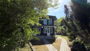 a house with a blue front door and trees at Villa TG for Large Families with Private Pool in Batumi