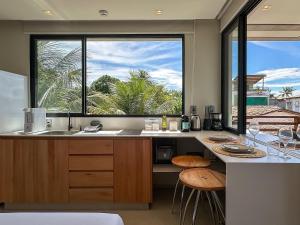 a kitchen with a counter and a large window at Chalé by Vila Manga Rosa in Pipa
