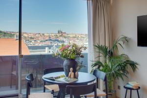 a room with a table with flowers and a window at Wenceslas Hotel & Apartments in Prague
