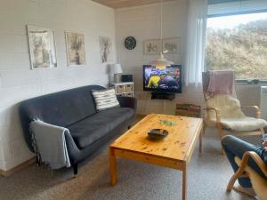 a living room with a couch and a coffee table at Sommerhuset i Saltum in Saltum