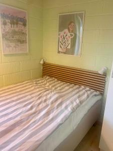 a bed in a room with two pictures on the wall at Sommerhuset i Saltum in Saltum