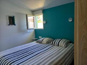 a bedroom with a bed with a blue wall at Le Marsalat - Lanton in Lanton