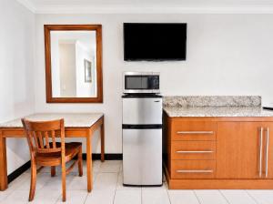 a kitchen with a refrigerator and a table and a mirror at Sunrise Inn in Wildwood
