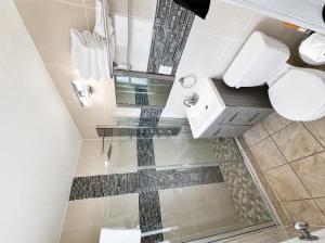 a bathroom with a toilet and a glass shower stall at Sunrise Inn in Wildwood +28 photos