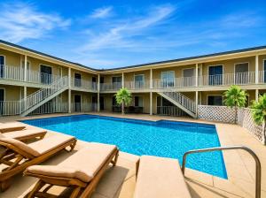 a pool at a hotel with chairs and a resort at Sunrise Inn in Wildwood