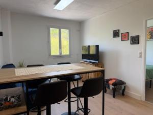 a room with a table with chairs and a television at Appartement refait dans ancien hôtel restaurant in Saint-Uze