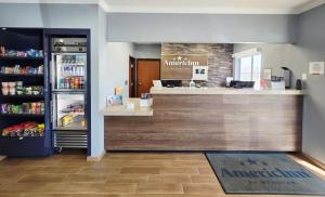 a restaurant with a counter and a refrigerator at AmericInn by Wyndham Minot in Minot