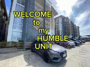 a car parked in a parking lot with the words welcome to my humble unit at Bayanihan flats Condo in Pajak