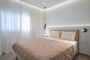 a bedroom with a large bed with white curtains at Casa John Kos Apartment in Zipárion