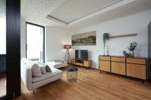 a living room with a white couch and a tv at Alte Weberei in Marktredwitz