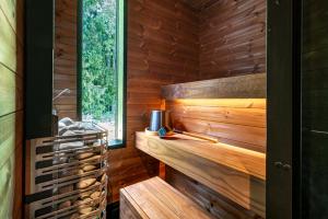 a sauna with wooden walls and a window at Arctic Nest Forest Cabin in Kotila