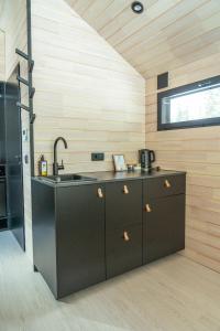 a kitchen with black cabinets and a sink at Arctic Nest Forest Cabin in Kotila