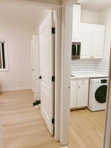 a kitchen with white cabinets and a washer and dryer at Comfortable 1BR Retreat, Private Entry in Richmond