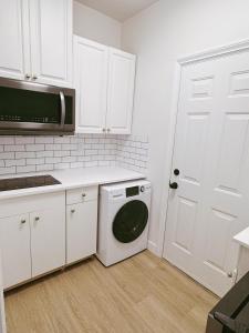 a kitchen with a washing machine and a microwave at Comfortable 1BR Retreat, Private Entry in Richmond
