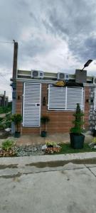 ein Haus mit weißen Fensterläden an der Seite in der Unterkunft Marcus Tiny House - Aesthetic in Cabanatuan City in Bangad