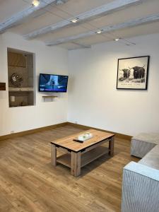 a living room with a coffee table and a couch at Maison de Village in Leuglay