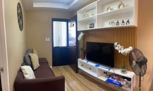 ein Wohnzimmer mit Sofa und Flachbildfernseher in der Unterkunft Marcus Tiny House - Aesthetic in Cabanatuan City in Bangad