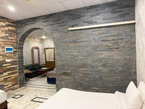 a brick wall in a room with a bed at Hayatt Palace Sukkur in Sukkur