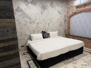 a bed in a room with a brick wall at Hayatt Palace Sukkur in Sukkur