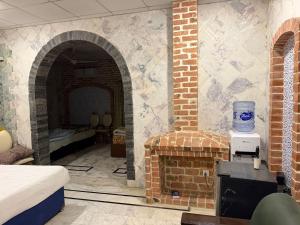 a room with a brick fireplace with a bed at Hayatt Palace Sukkur in Sukkur