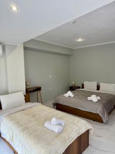 two beds in a room with towels on them at Villa Athina BC in Serres