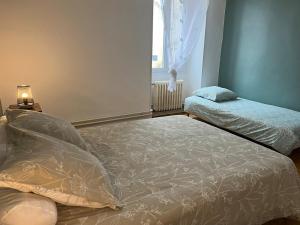 a bedroom with two beds and a window at Maison de Village in Leuglay