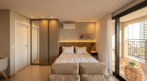 a bedroom with a bed and a large window at Facilidade no Coração da Cidade in Campo Grande +12 photos