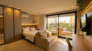 a bedroom with a bed and a couch and a window at Facilidade no Coração da Cidade in Campo Grande