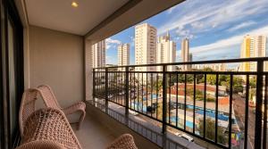 a balcony with chairs and a view of a city at Facilidade no Coração da Cidade in Campo Grande