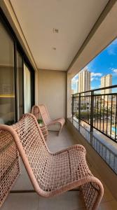 two wicker chairs on a balcony with a view at Facilidade no Coração da Cidade in Campo Grande