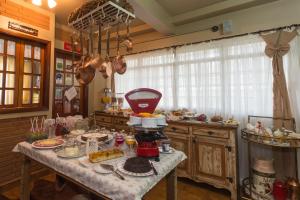 a kitchen with a table with food on it at Pousada Jardon in Campos do Jordão