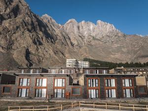 a large brick building with mountains in the background at FortuNorth in Skardu
