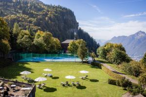 an aerial view of a resort with a pool in a grass field at Wellness Hotel Stoos in Stoos