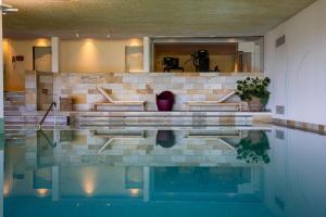 a house with a swimming pool in the middle at Wellness Hotel Stoos in Stoos