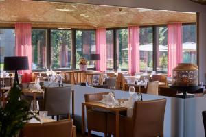 a restaurant with tables and chairs and windows at Wellness Hotel Stoos in Stoos
